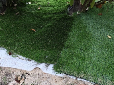 Un vrai poseur de gazon synthétique pose dans le bon sens